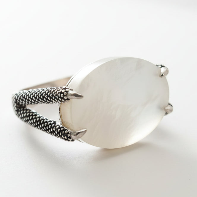 Silver ring with a large stone on a white background