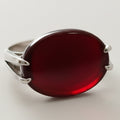 Silver ring with a red stone on a white background