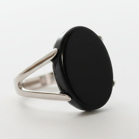 Silver ring with a black stone on a light background