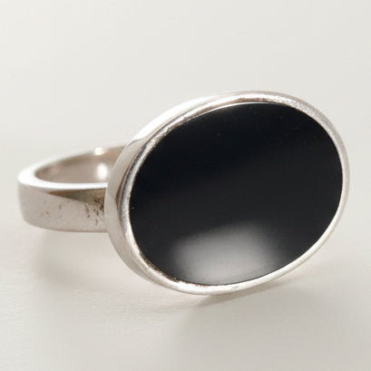 Silver ring with a black stone on a white background