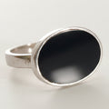 Silver ring with a black stone on a white background