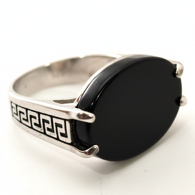 Silver ring with a black stone on a white background